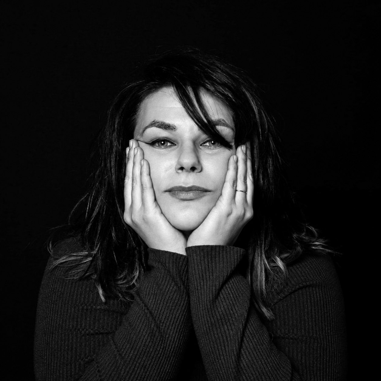 Black and white portrait of Maria Pushevska resting her face in her hands
